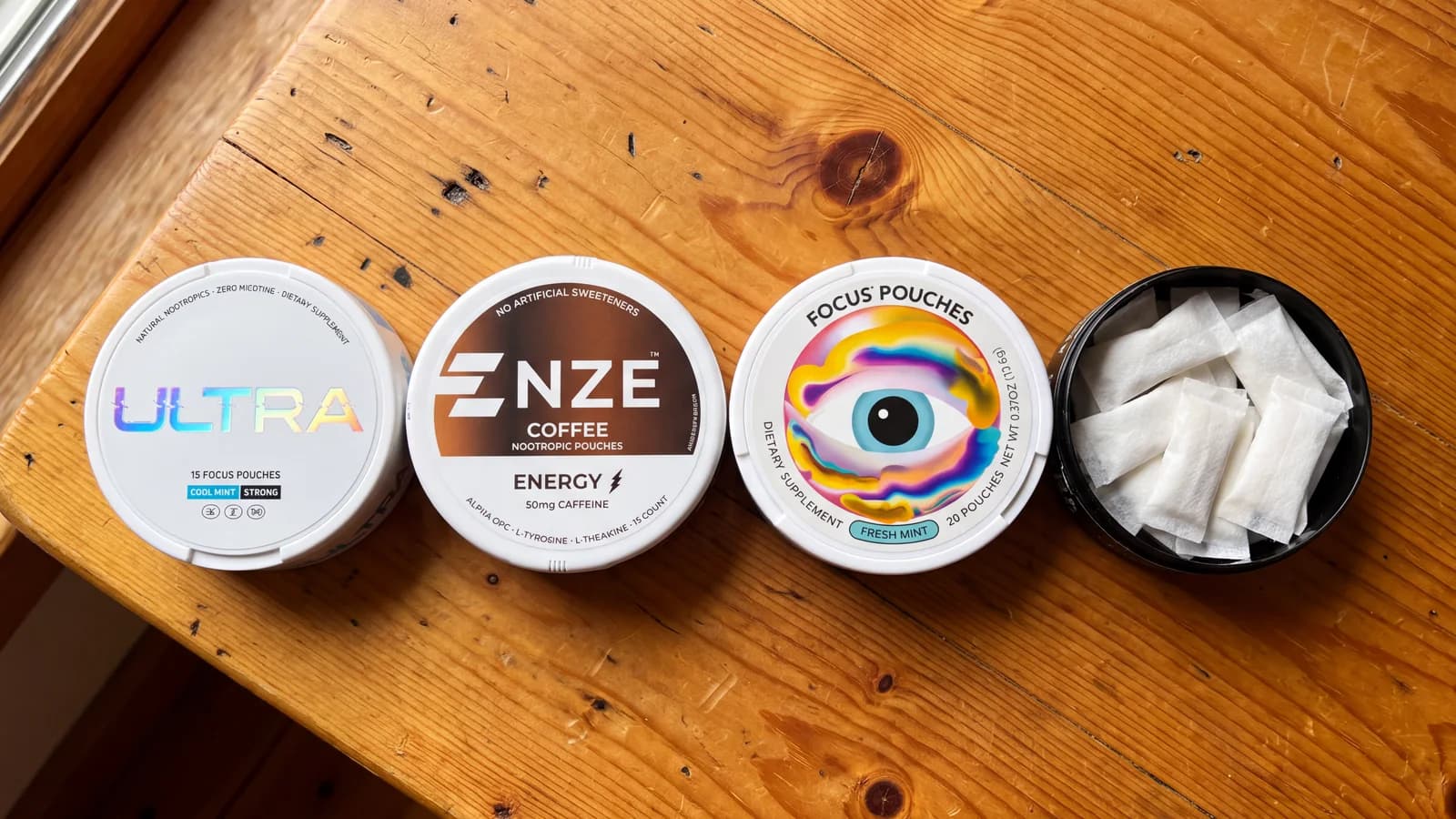 Ultra Focus, NZE, Neutonic Focus Pouches and an open Fully Loaded tin on a wooden table