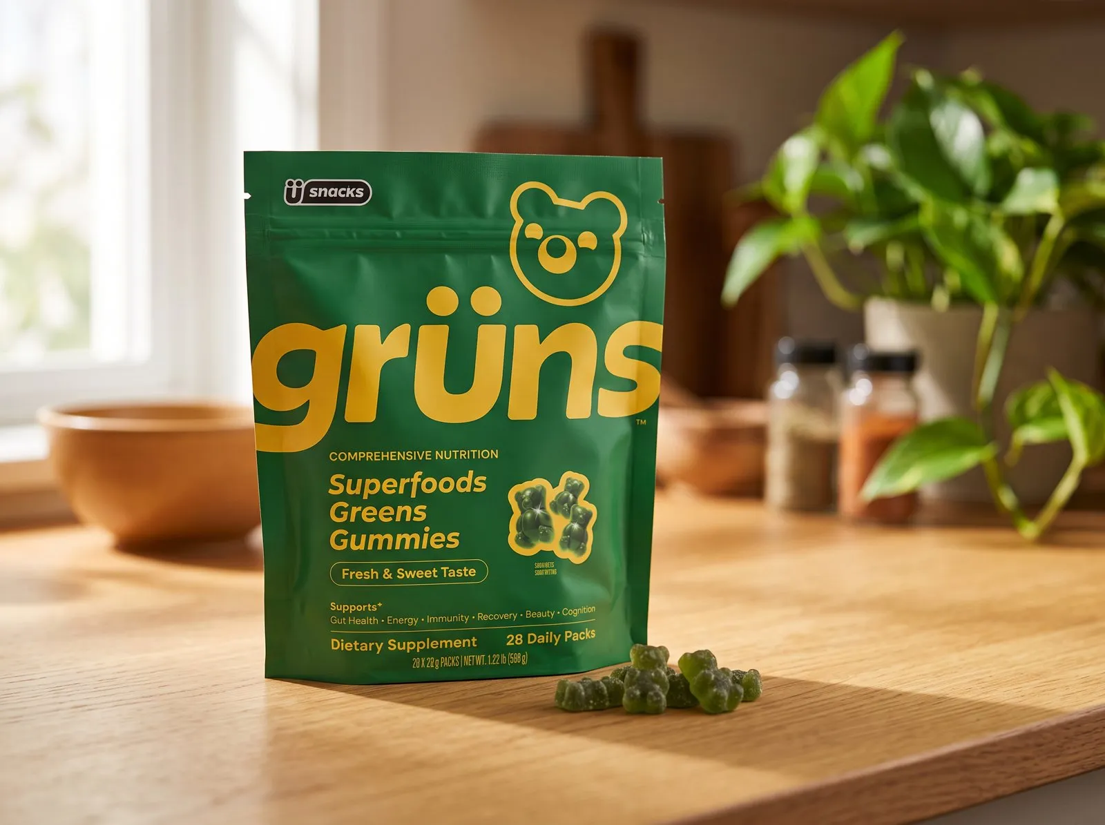 Grüns greens gummy pouches and a glass of green gummies on marble.